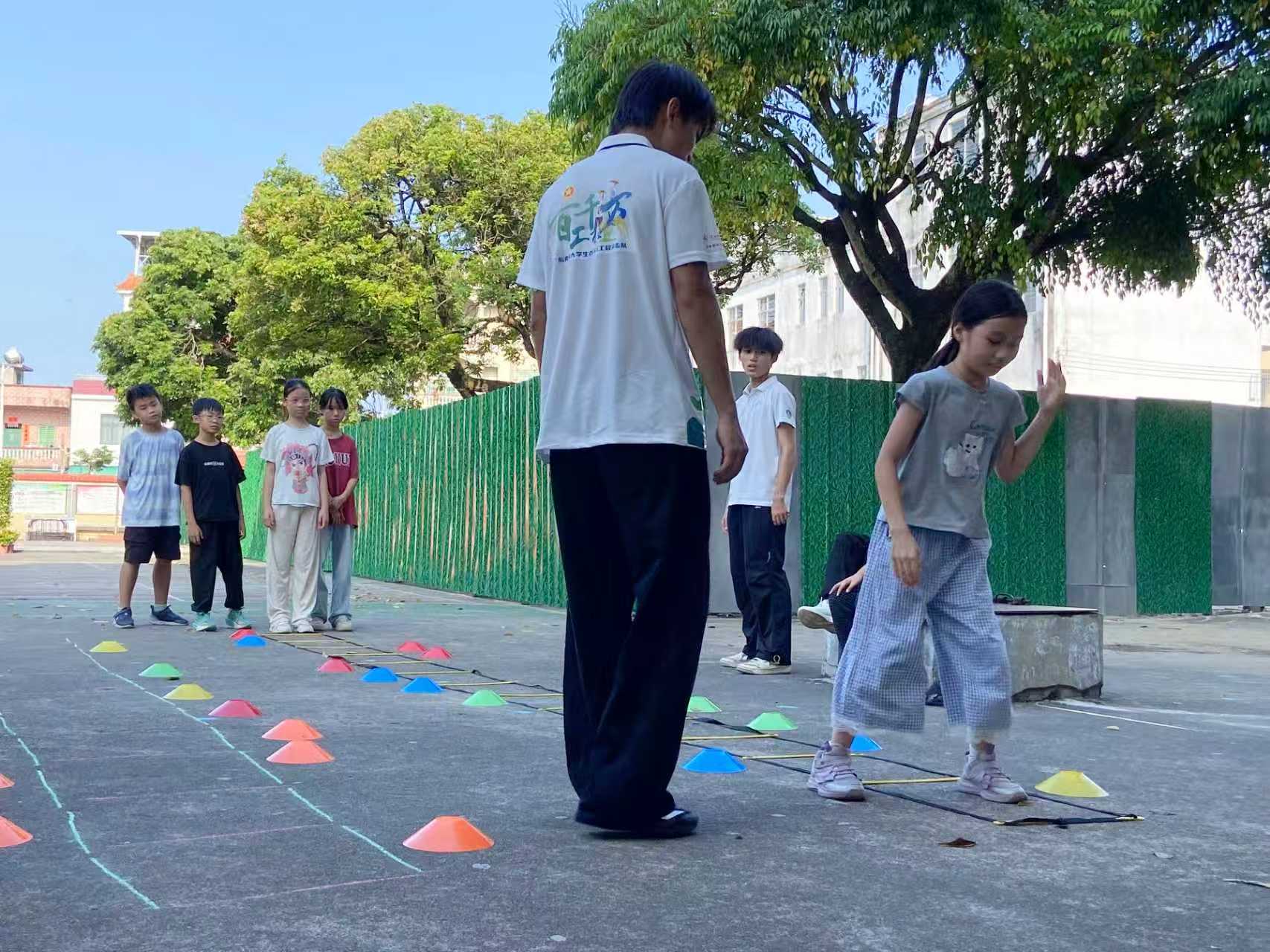 图为实践队员利用敏捷梯开展体适能趣味训练。红旅新征实践团 供图