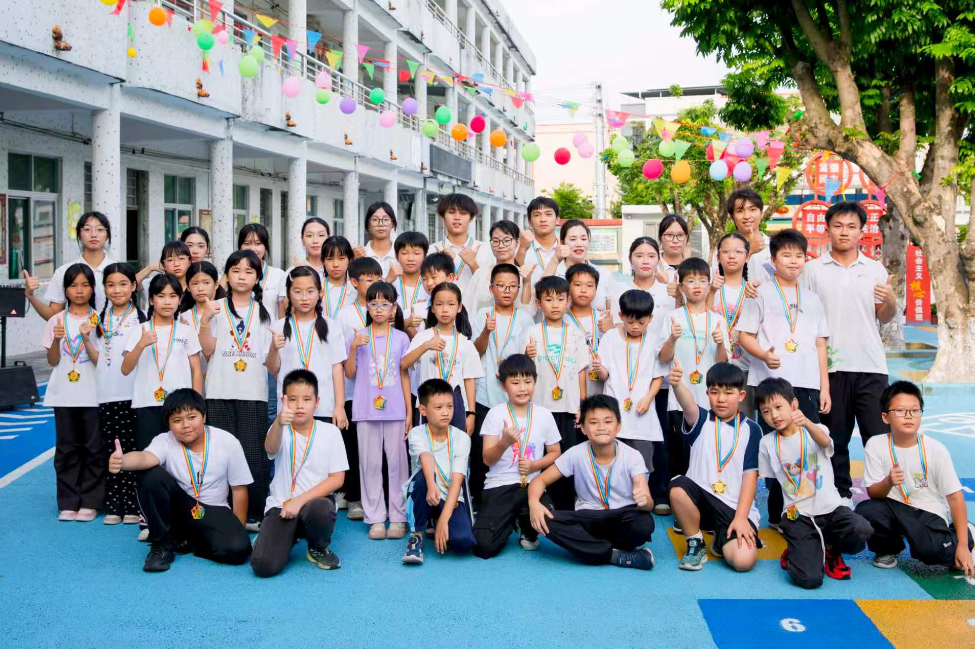 图为结营汇演结束后，实践队员为小学生颁发结营奖牌并合影留念。红旅新征实践团 供图 ... ... ... ...