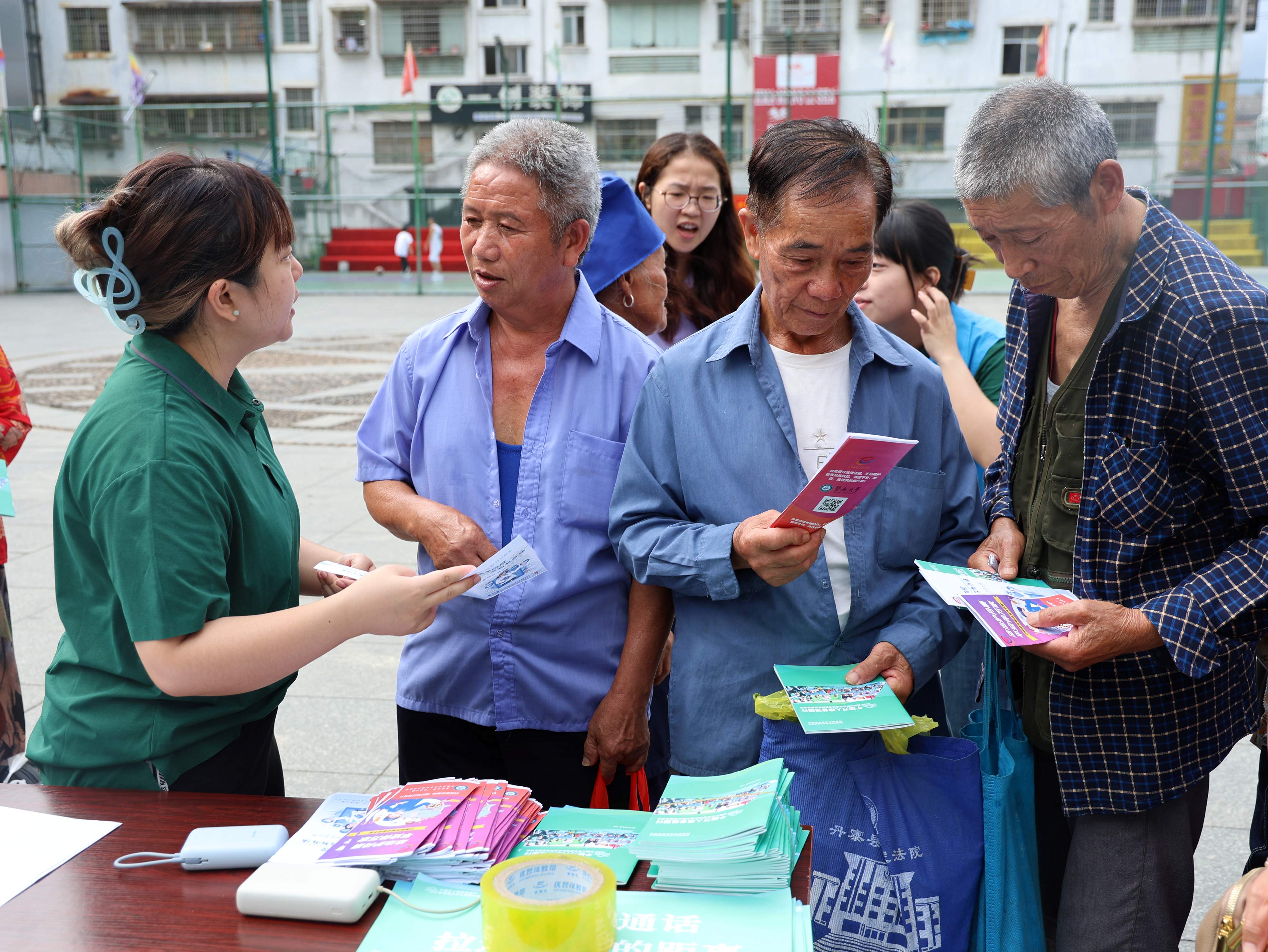图为实践团成员在集市摆摊时为居民发放宣传单科普法律知识和慢性病知识.JPG