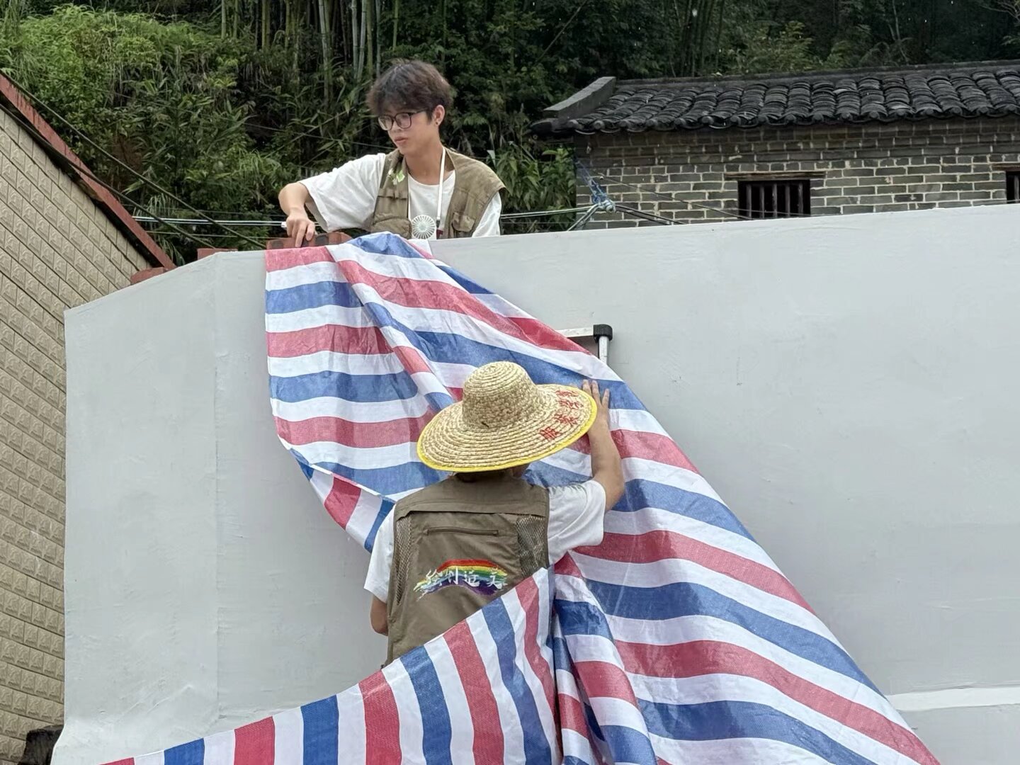 图为突击队队员搭建遮雨棚现场  拍摄者：胡千羽
