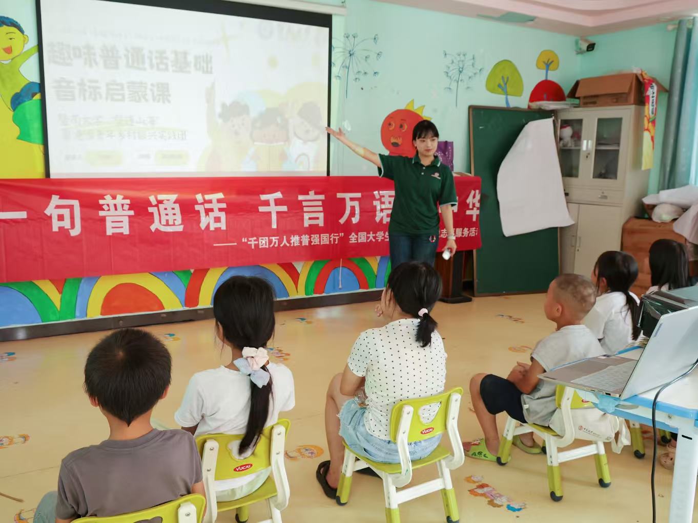 团队成员在给孩子们讲解拼音音标.jpg